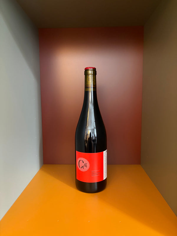 Wine bottle with dark glass and red front label, foil-lined neck and cap