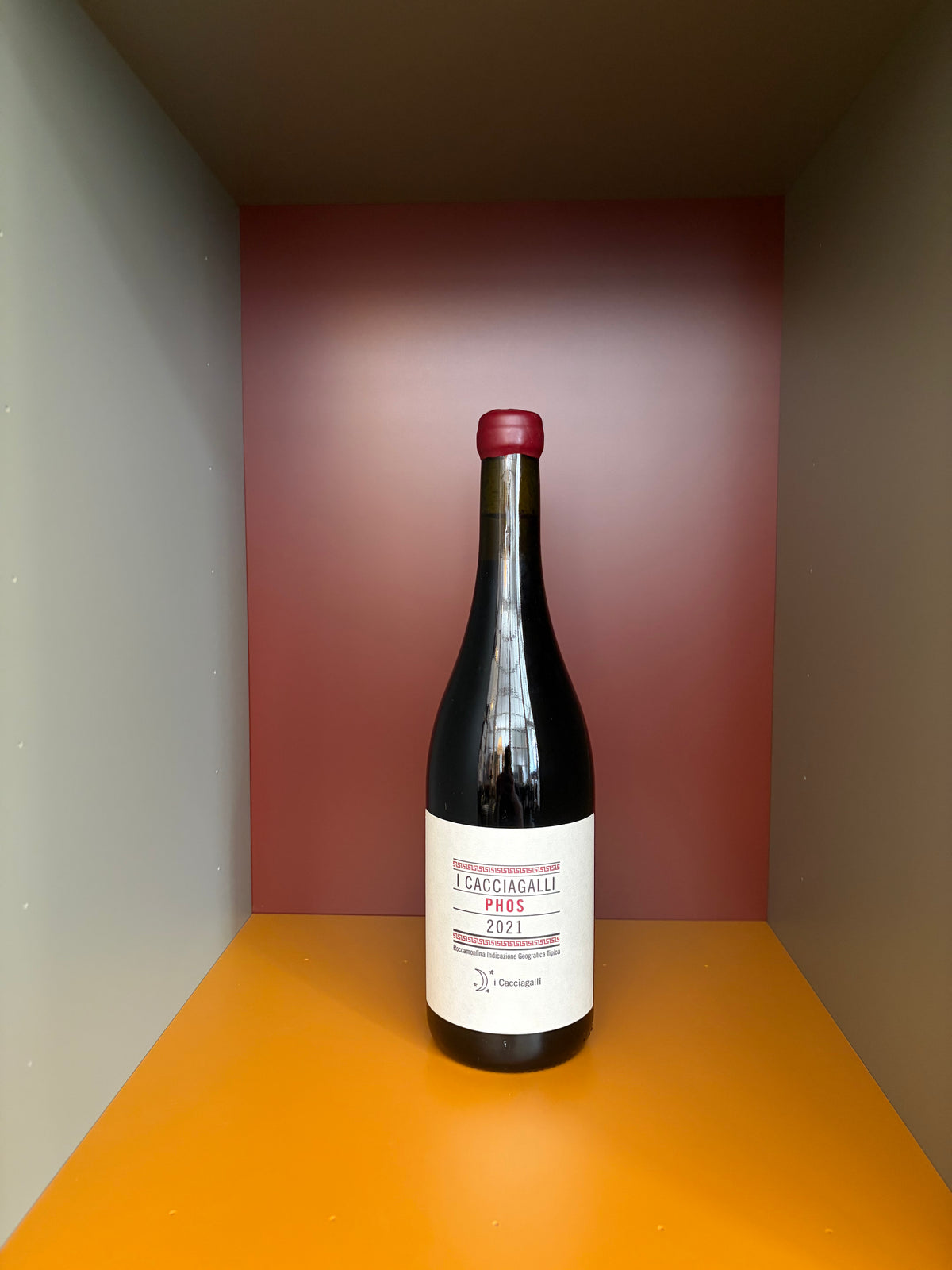 Wine bottle with red cap and white label, dark glass