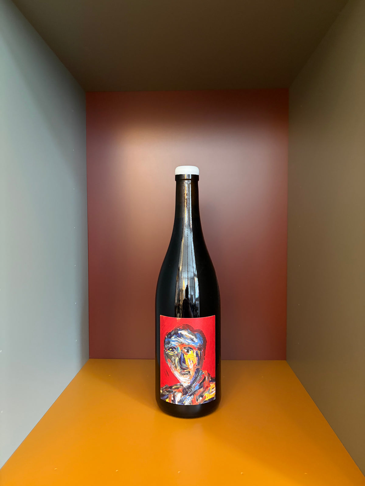 Wine bottle with dark glass and white cap, colorful abstract label