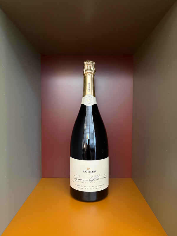 Magnum sparkling wine bottle with gold foil cap and cream label on dark bottle